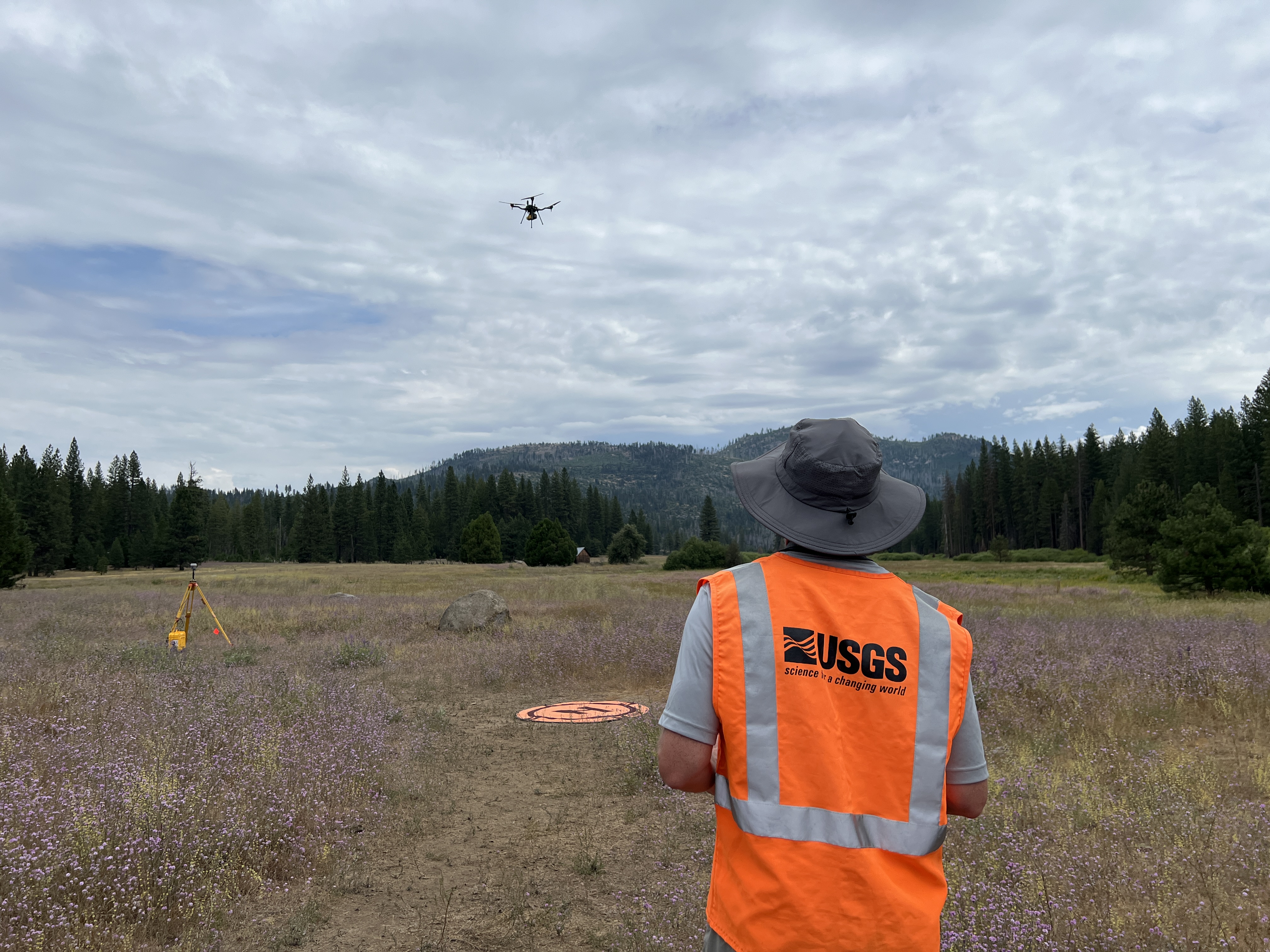 UAV pilot flying a LiDAR mapping drone with surveyed ground control in mountainous terrain