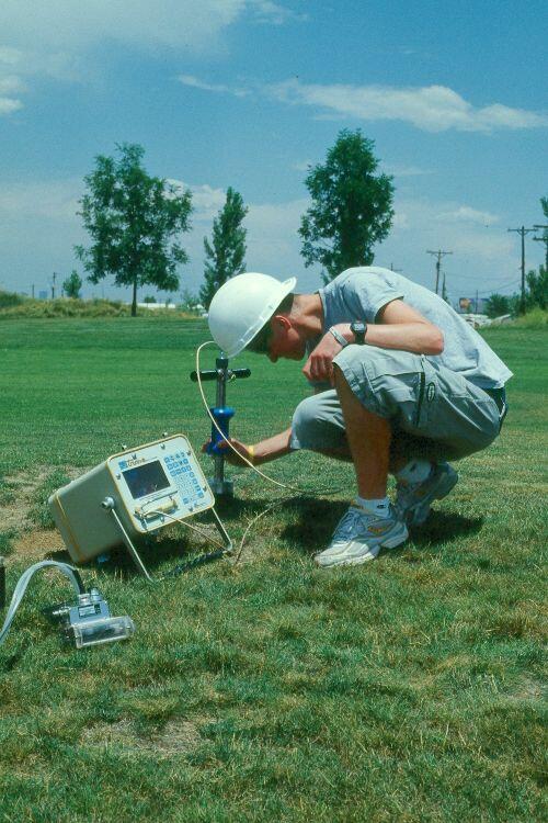 Student volunteer measuring soil moisture & greenhouse gases.