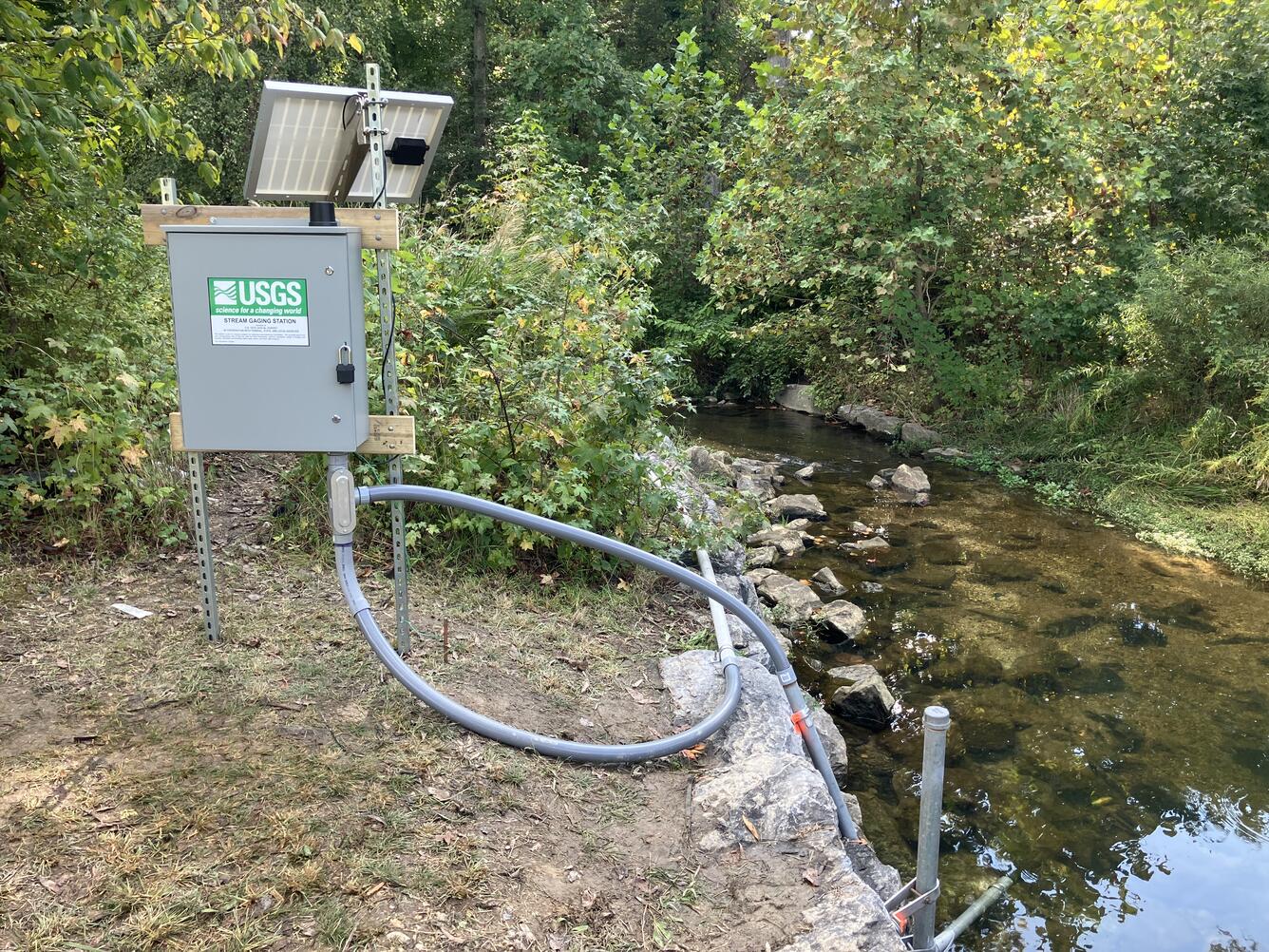 A gage box adjacent to a stream.