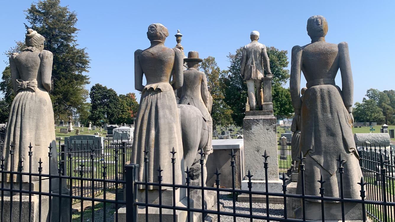 Backside view of weathered sandstone human figures representing members of Wooldridge family