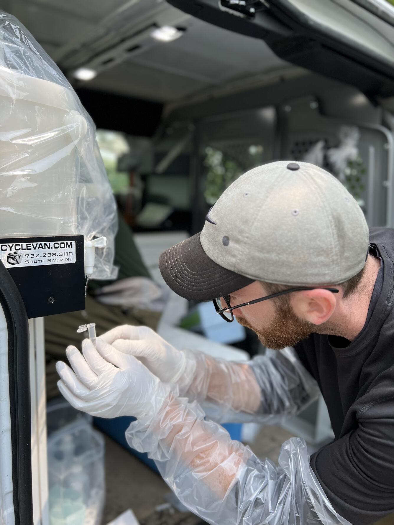 Lucas Sirotniak samples PFAS in surface water at the Delaware River at Trenton, NJ. Photo by Jacob Gray. 