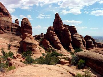 This image shows the red rocks of Klondike Bluffs. They are massive rock structures that have rounded tops by erosion. 