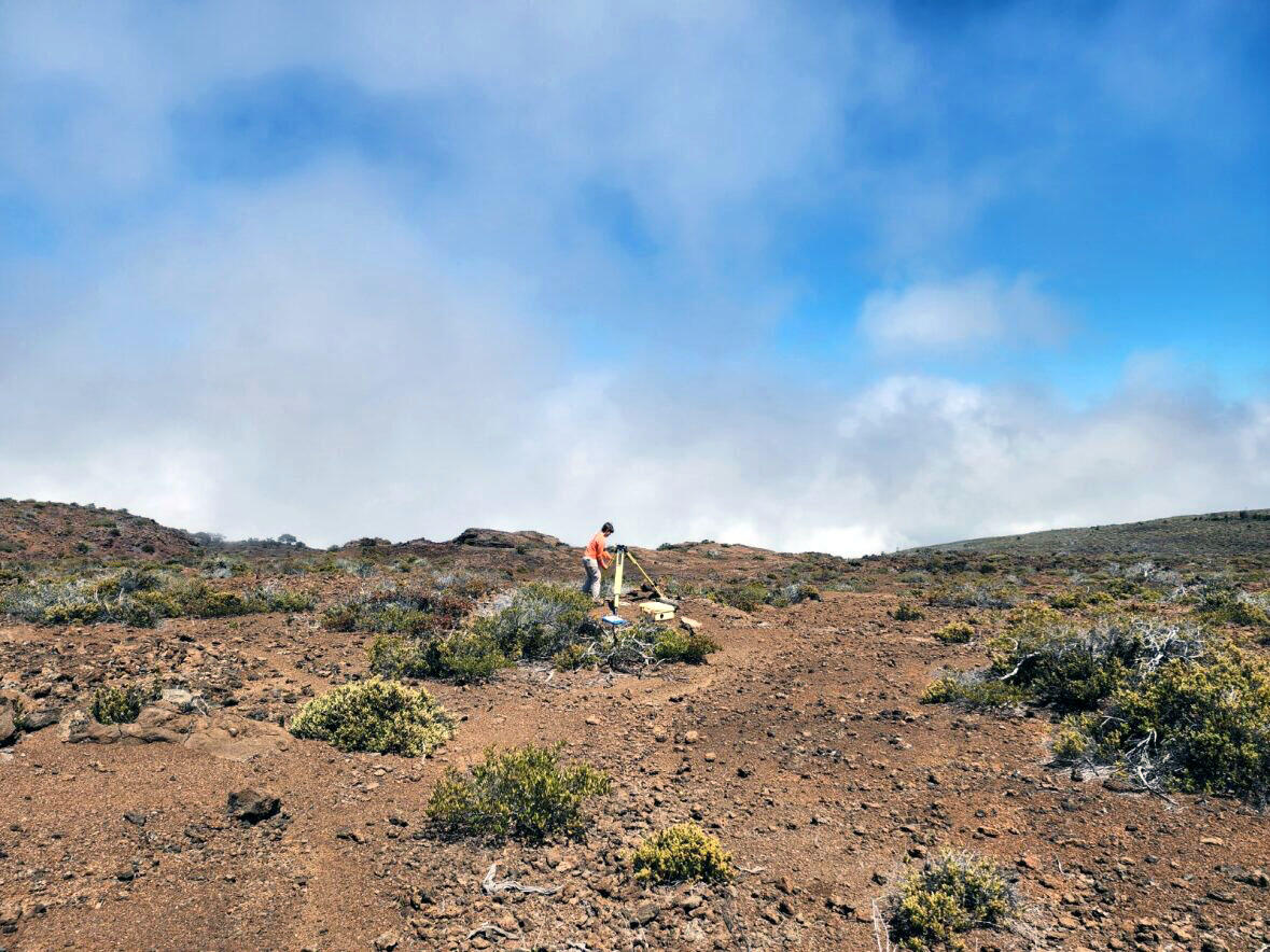 Color photograph of scientist deploying instrument in the field