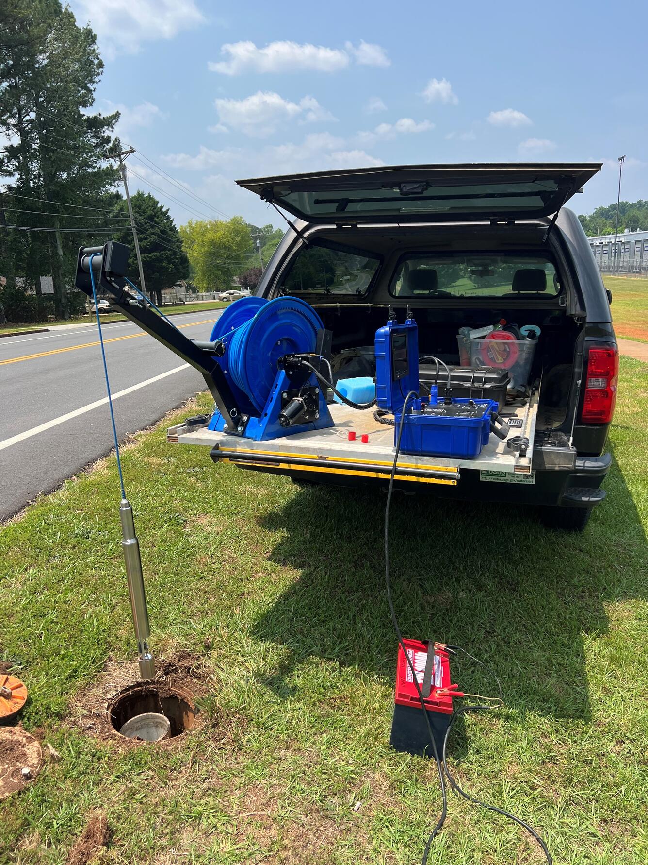 Camera sensor being lowered into a well, using an electric winch.