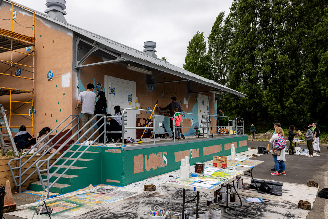 WFRC staff and community volunteers painting the mural on the storage building