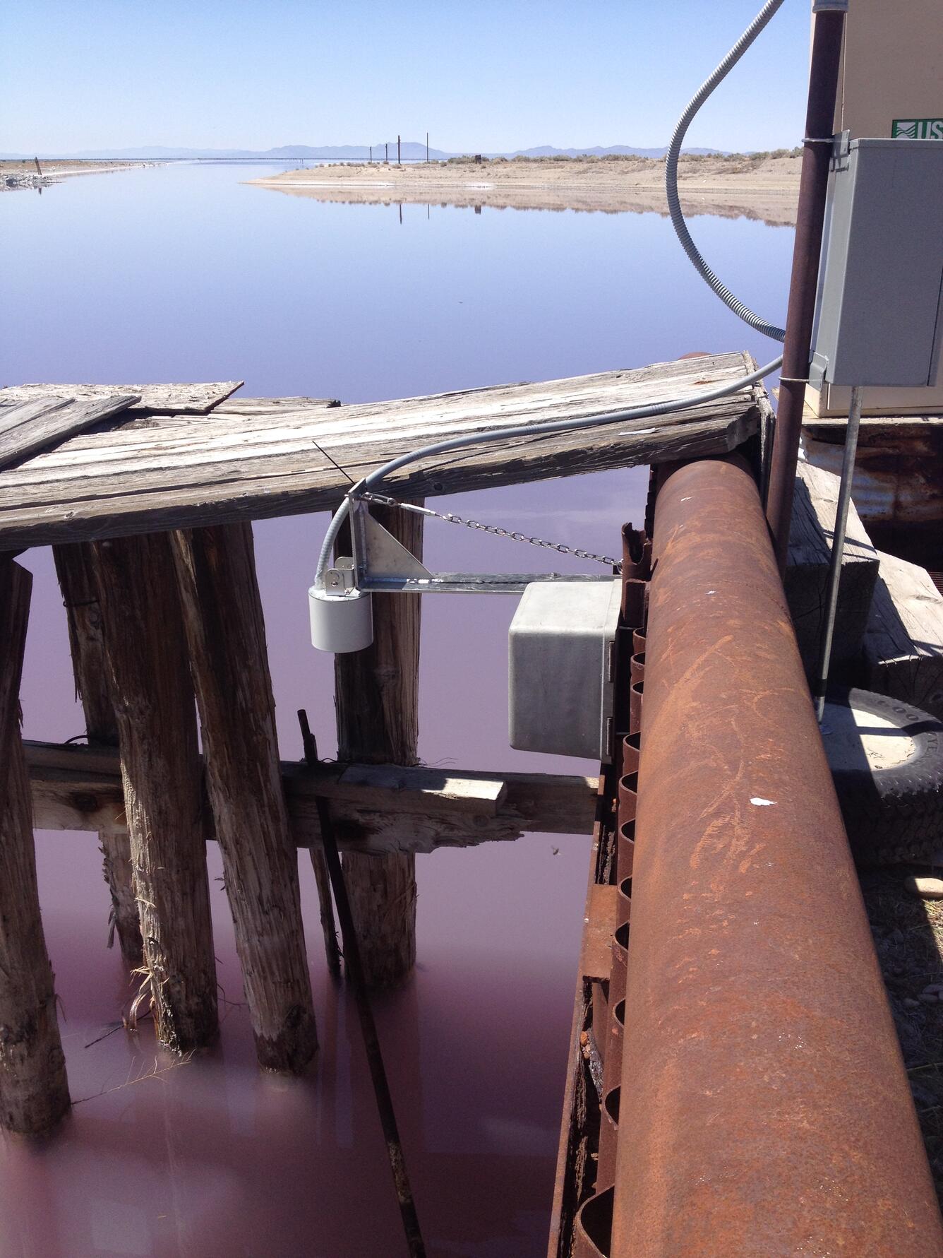 View of radar instrumentation and harbor outlet in background to very pink north arm of Great Salt Lake.