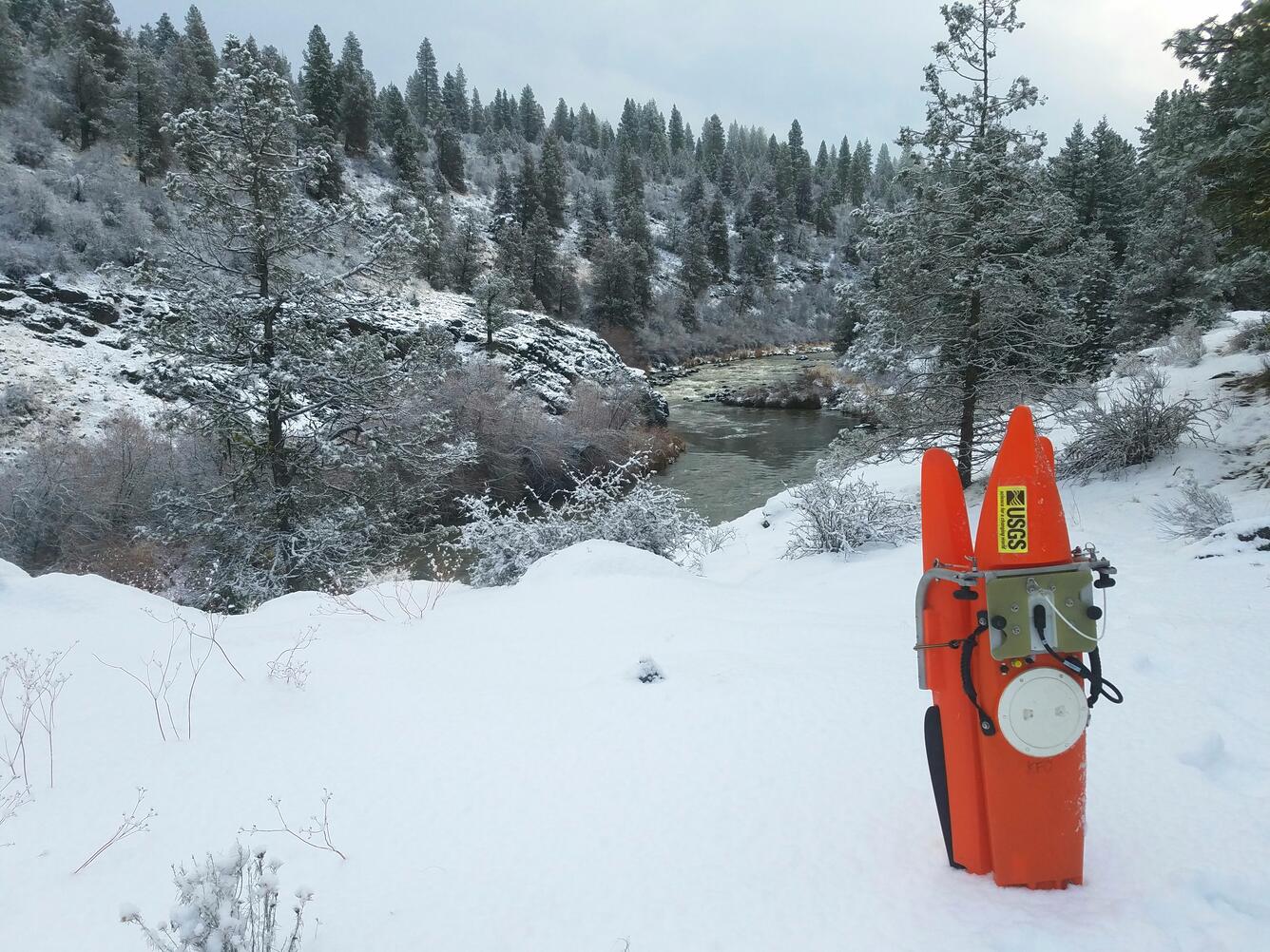 A RiverPro ADCP in an orange pontoon is propped in the snow near Klamath River. 