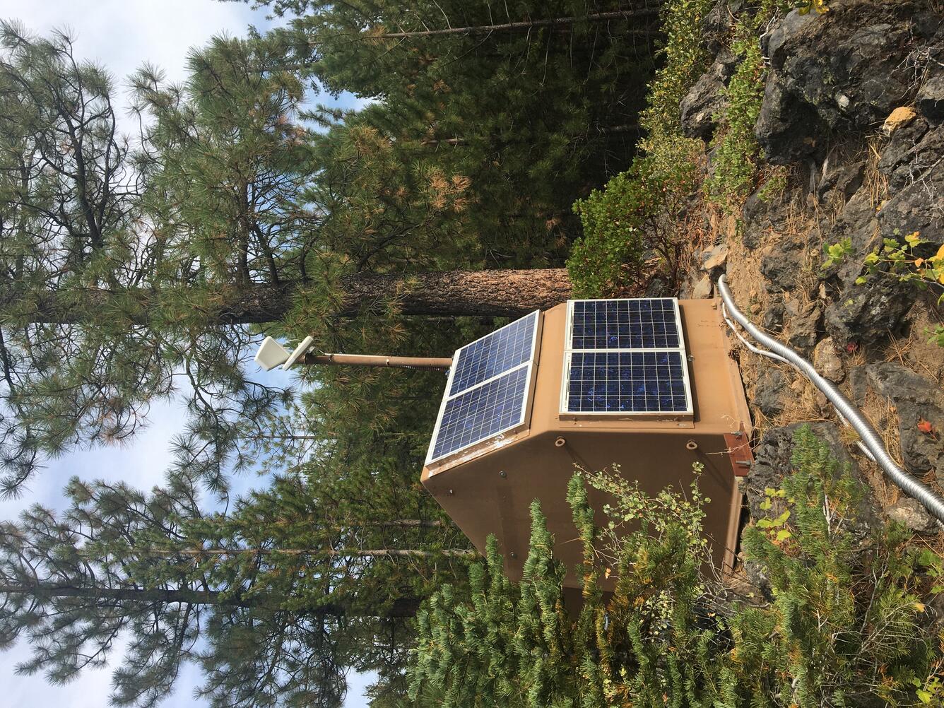 Brown hut in forest houses volcano monitoring equipment