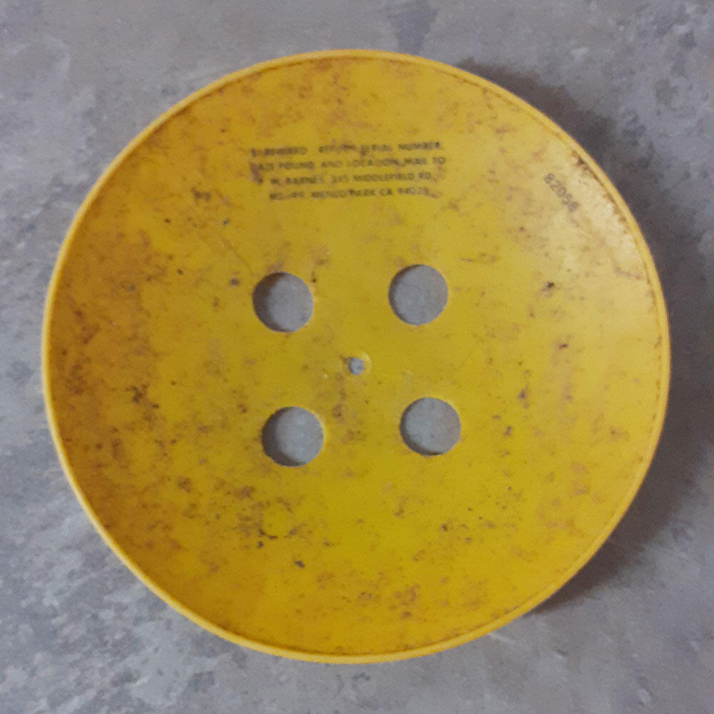 Yellow plastic disk with evenly spaced holes in the middle.