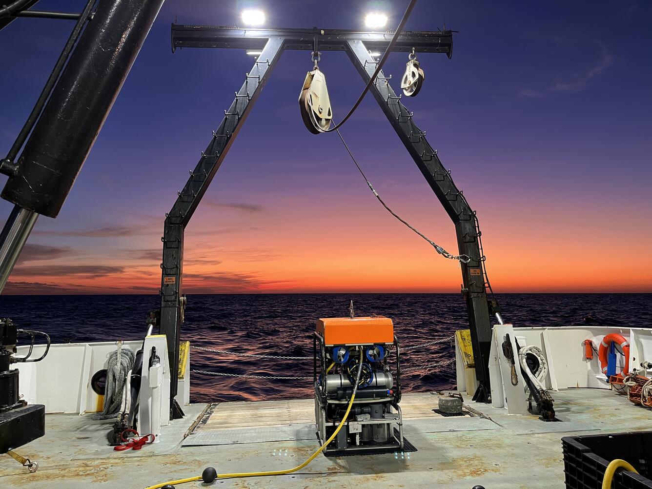 A undersea robot sits on the stern of a research vessel in the Gulf of Mexico at sunset