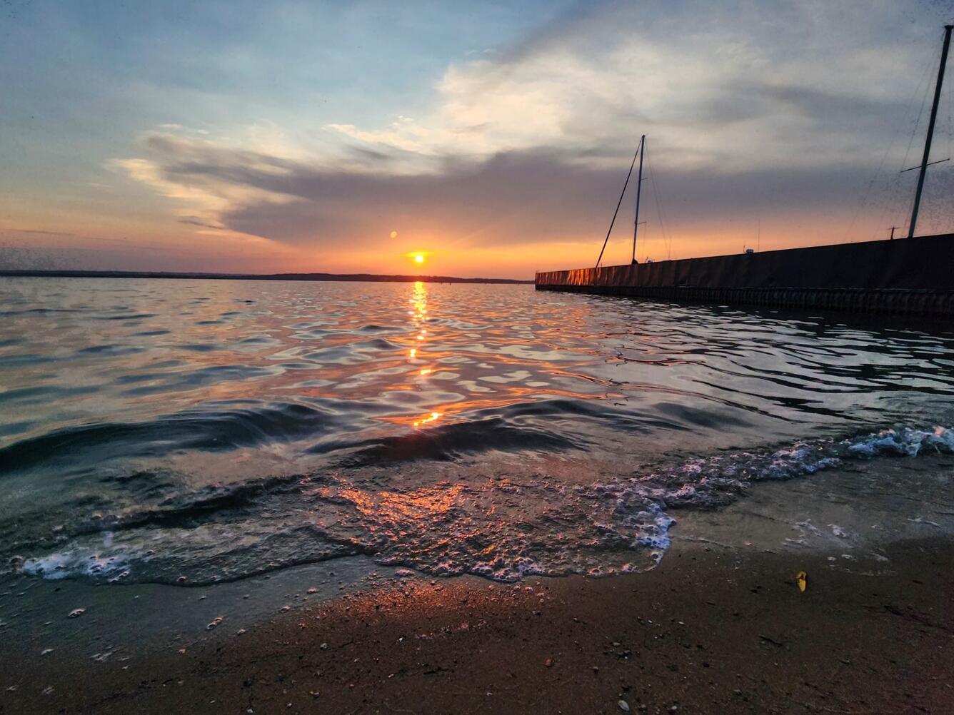 Sunset on the shore of Lake Michigan near a long pier