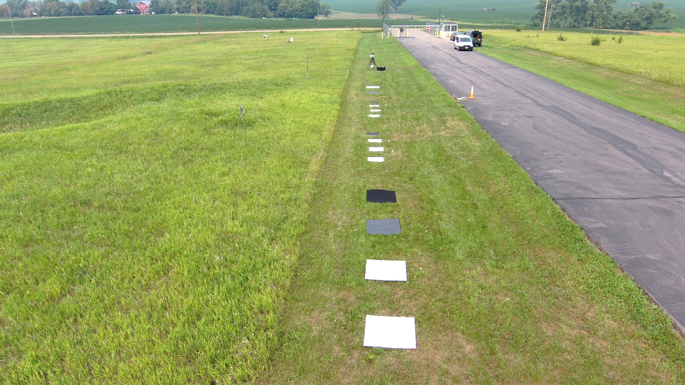 Square, colored reference targets spaced in the grass along roadside