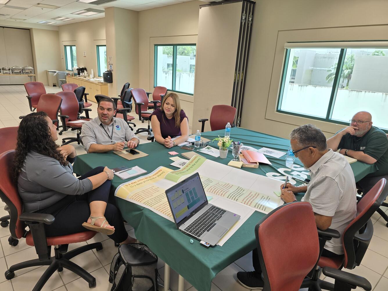 A group of five people are having a table discussion.