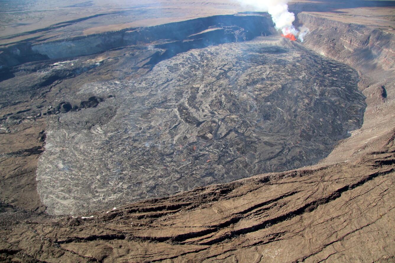 Color photograph of caldera with fresh lava flows and active eruption