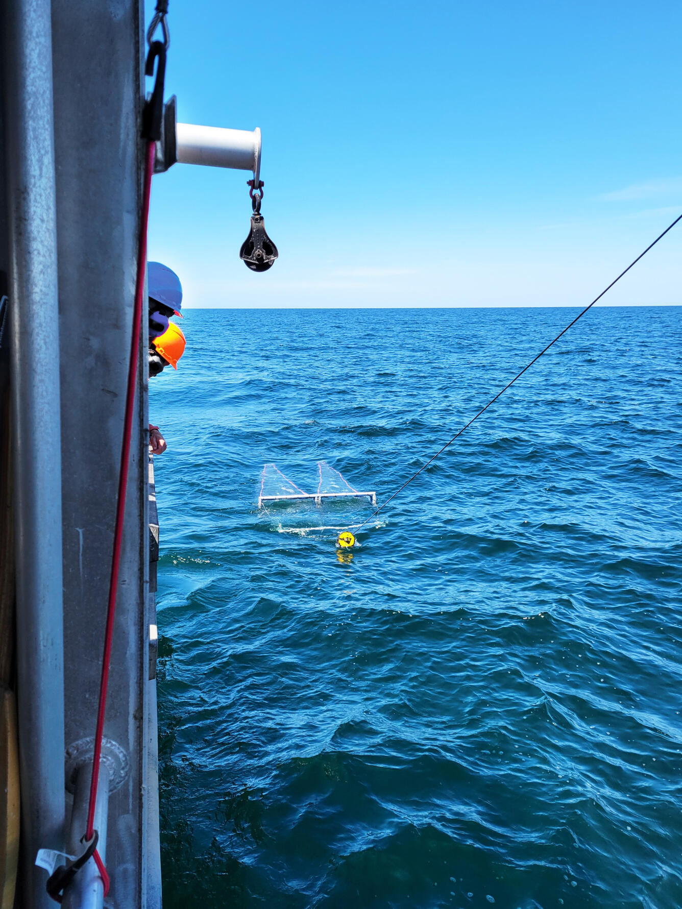 A neuston net being towed alongside a large research vessel in Lake Ontario