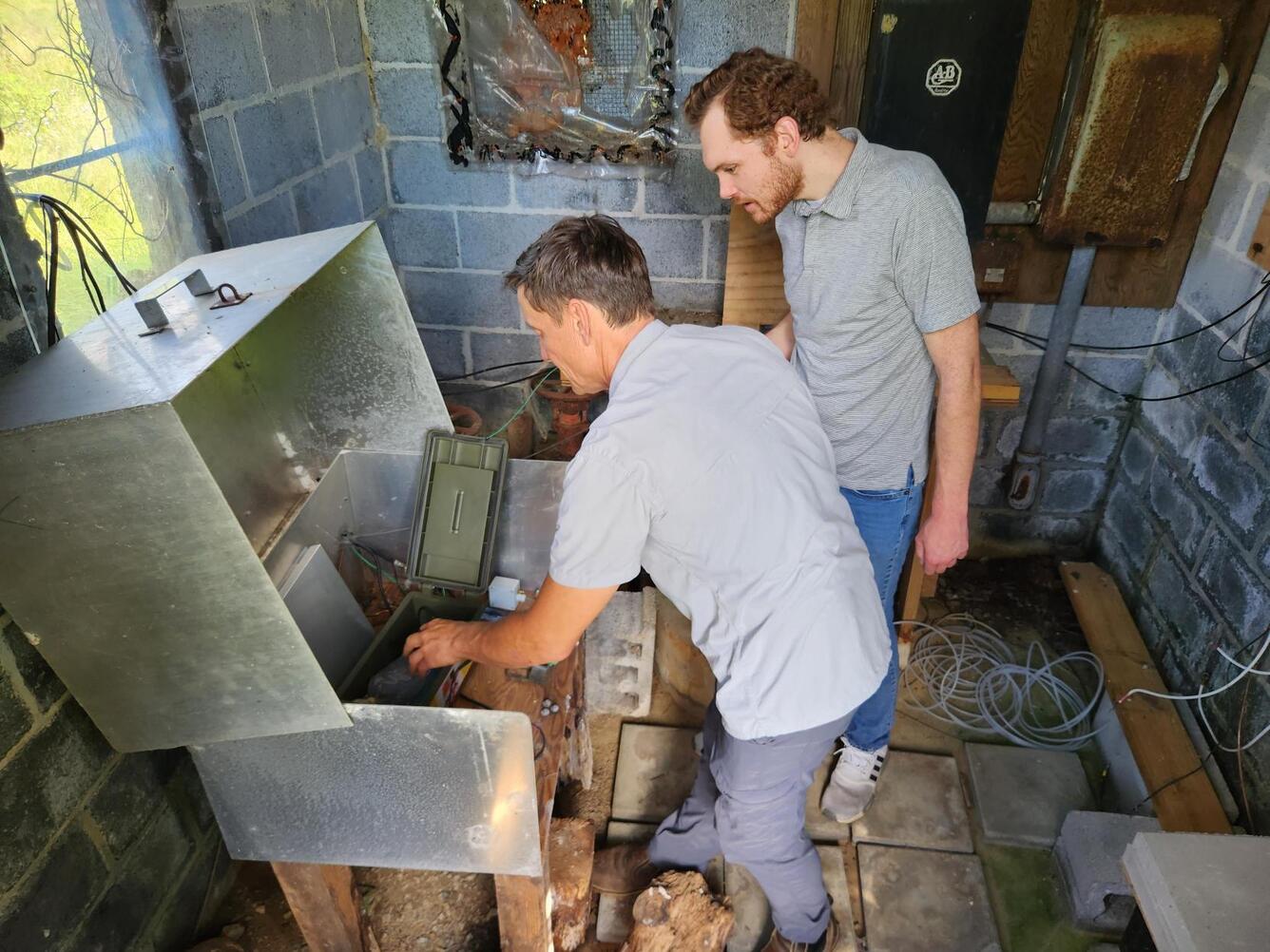 A scientist shows a reporter the various monitoring equipment used to record and transmit water level data.