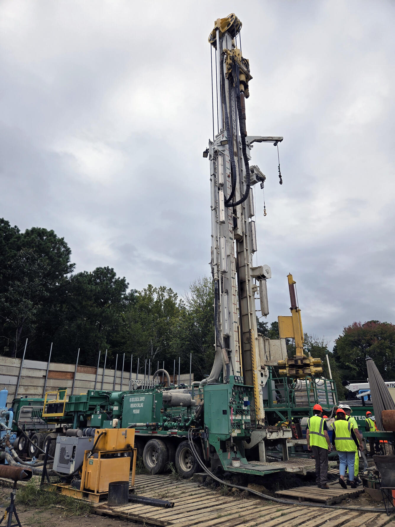 A drilling rig at the site of the James River Extensometer. Several individuals in hardhats and safety vests tour the rig.