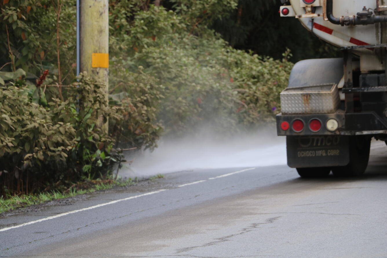 Color photograph of truck cleaning ash 