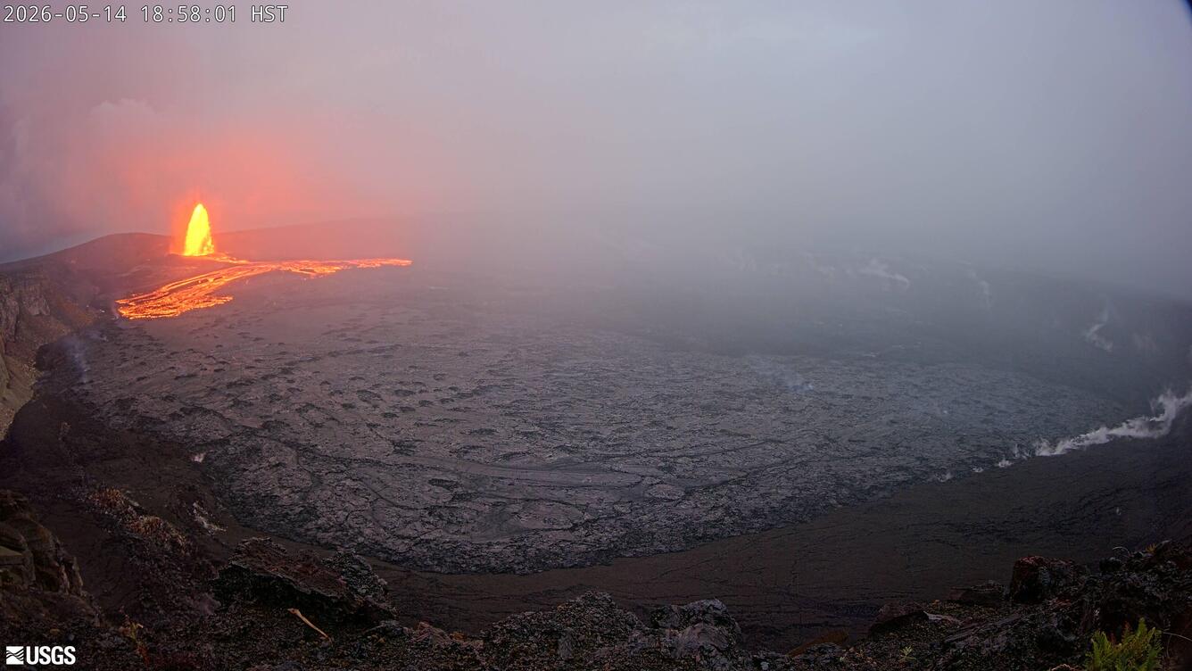 Color photograph of lava fountain and lava flow within crater