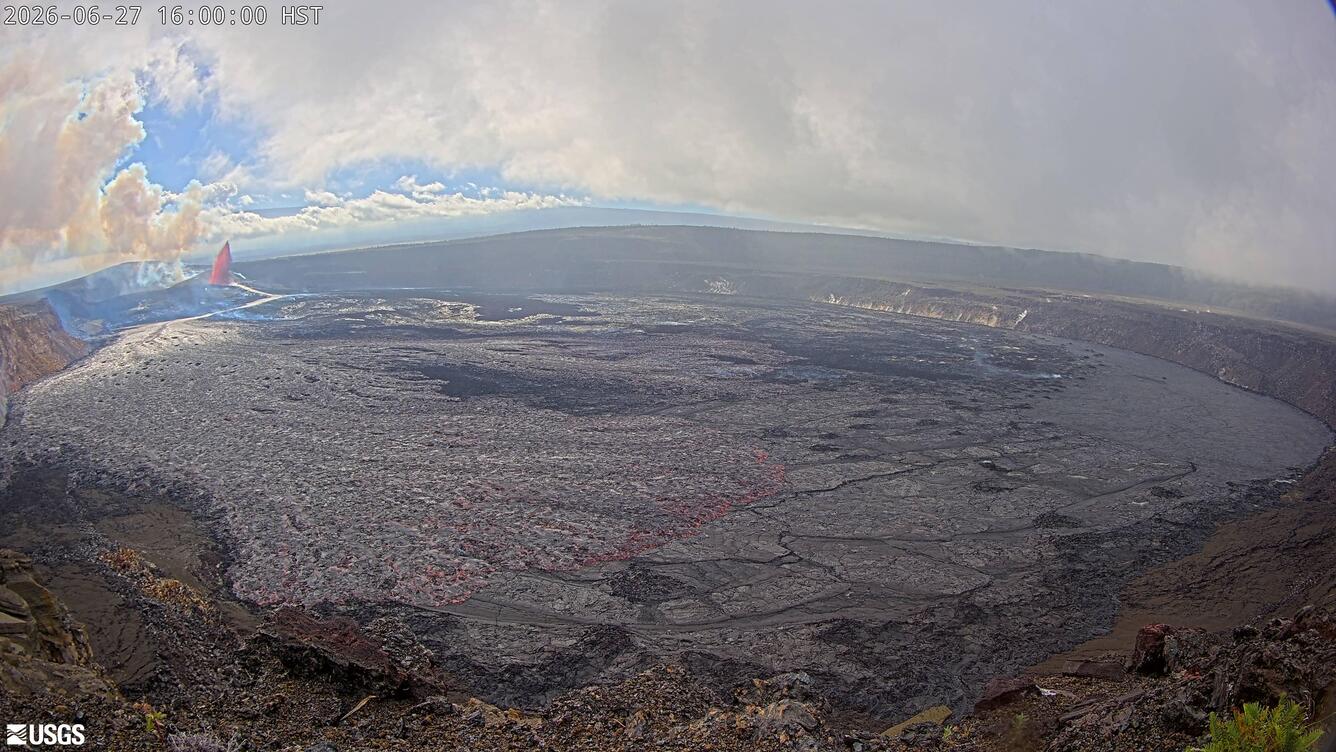 Color photograph of lava fountain within crater in the background with lava flows in the foreground