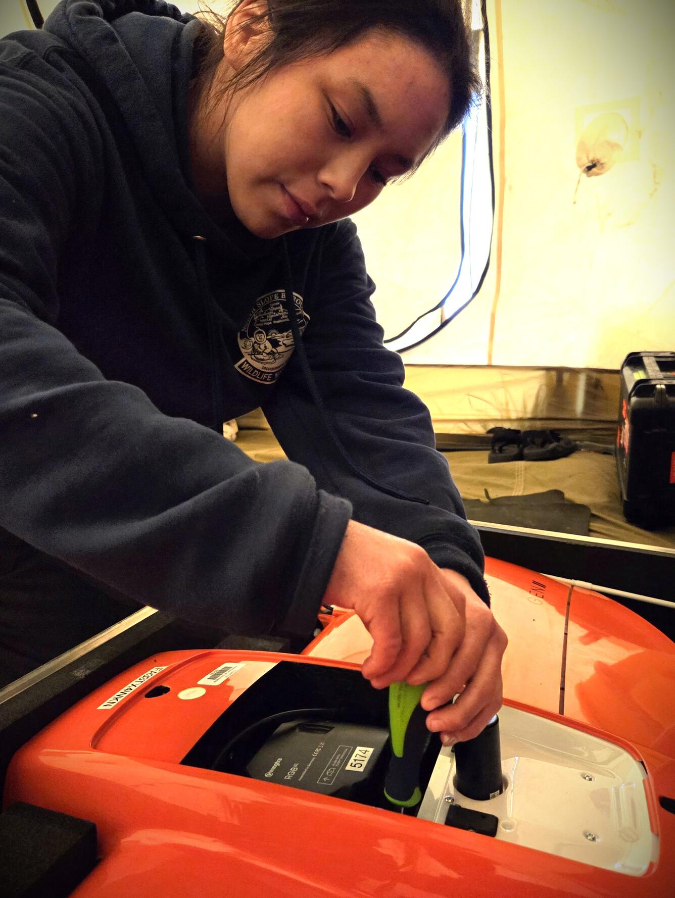 A girl using a screw driver.