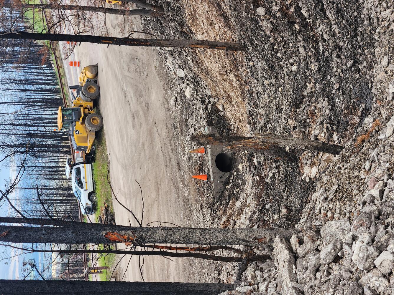 heavy equipment parked on road near watershed outlet