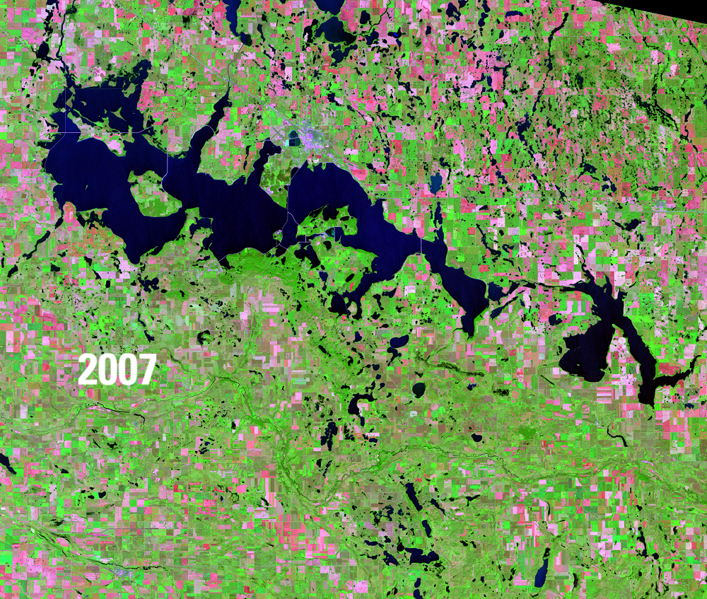 Satellite image showing water bodies in deep blue, green vegetation and pink barren areas