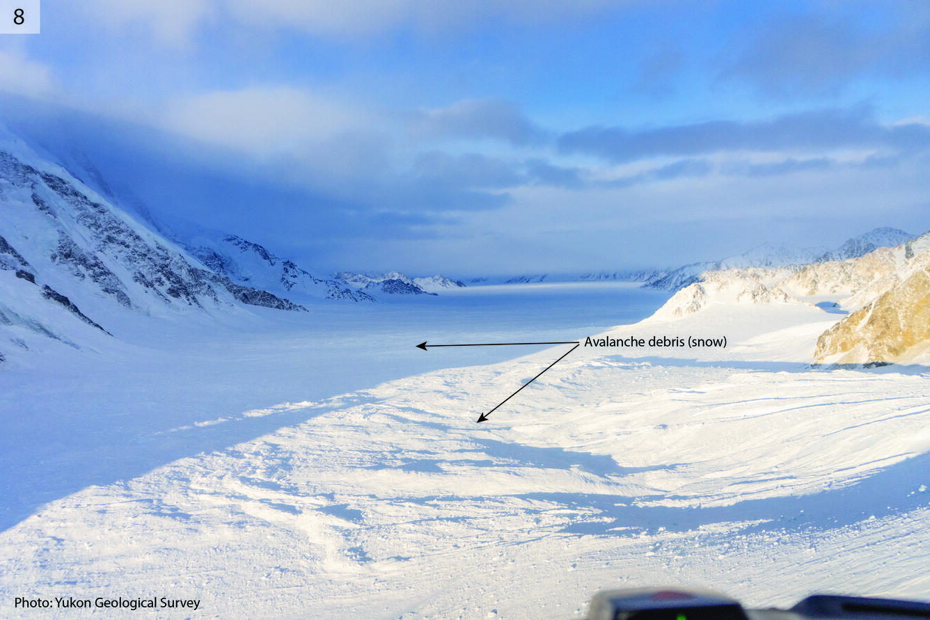 Snowy valley with label pointing out avalanche debris