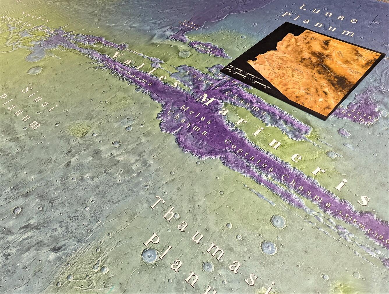 Photo of a huge topographic map of Mars on the floor with a map of Arizona printed to scale