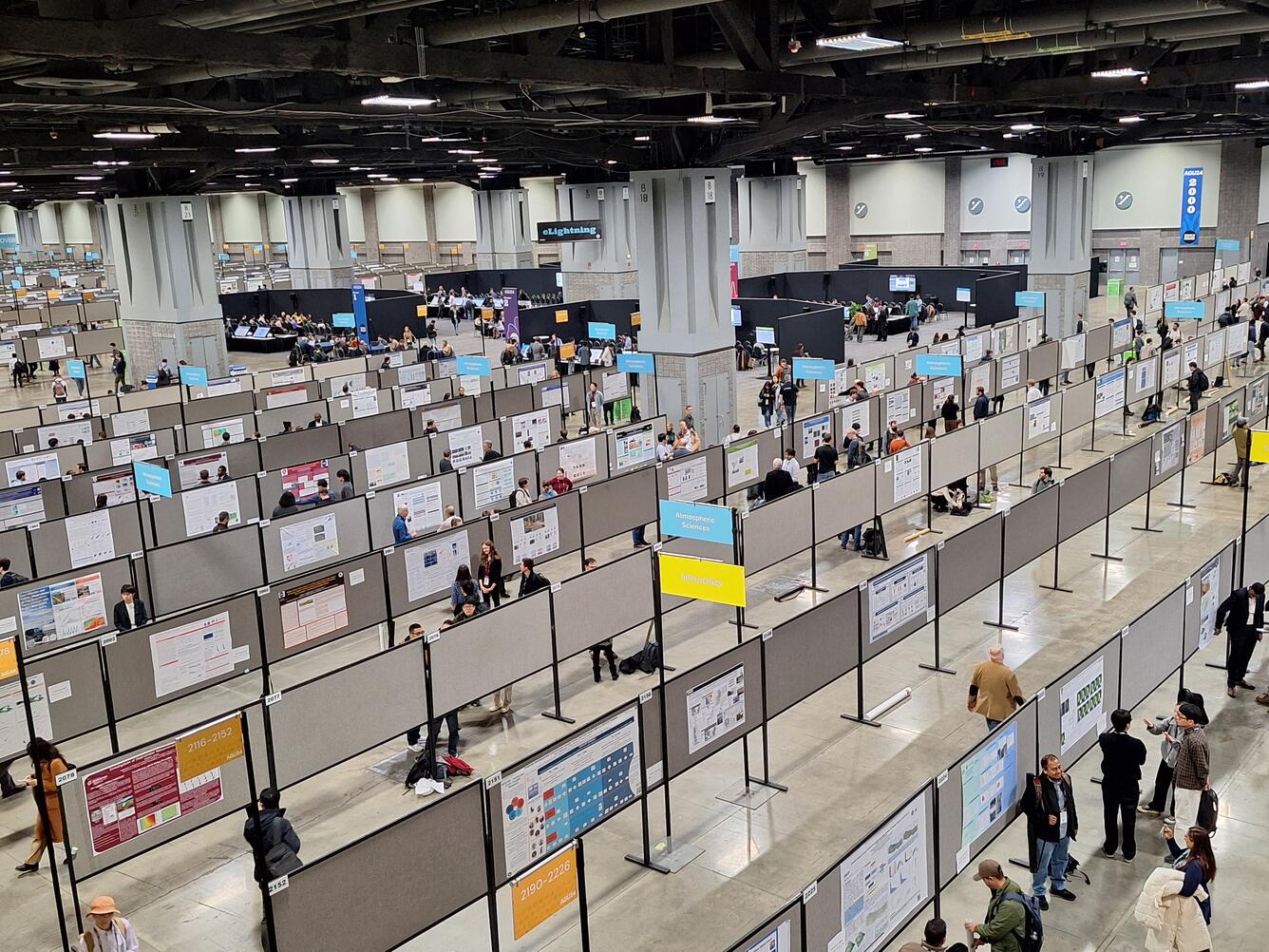 An aerial view of posters hanging in a convention hall.
