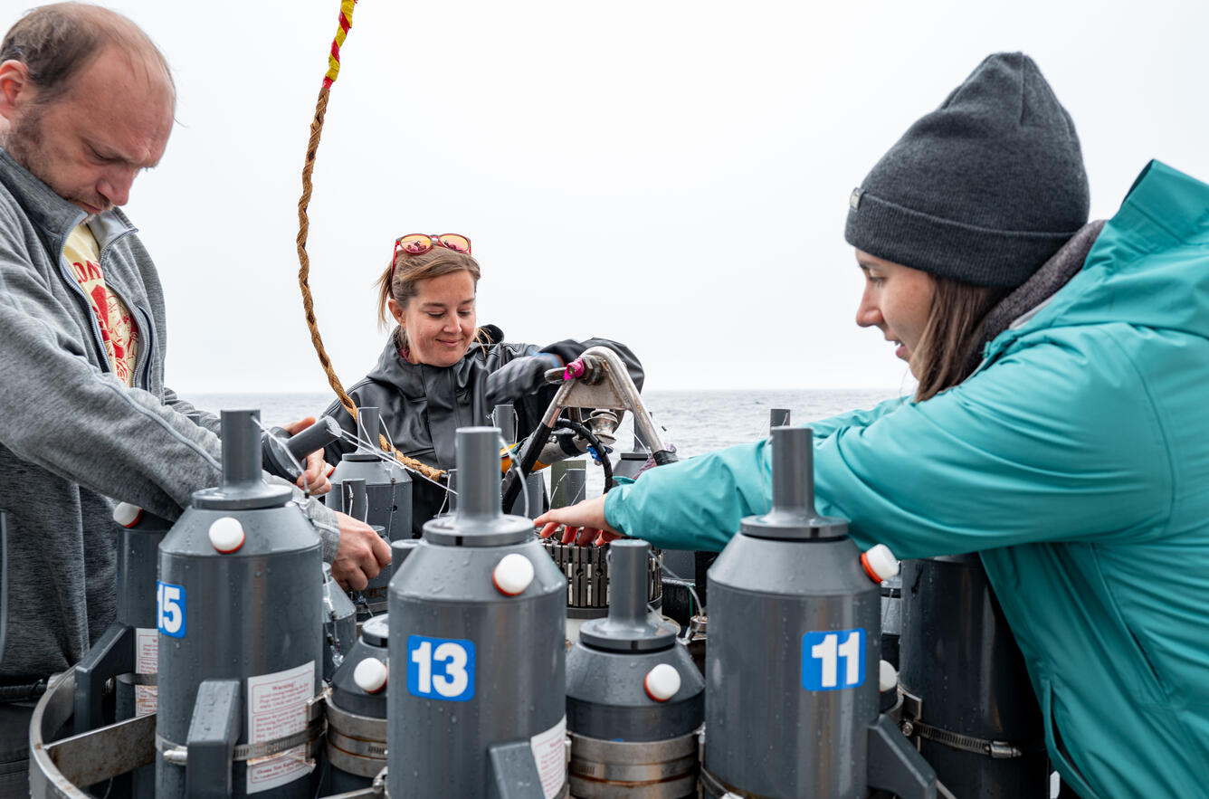 Three people prepare a CTD for deployment