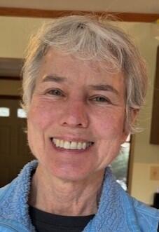 Woman with short blond hair smiling at camera 