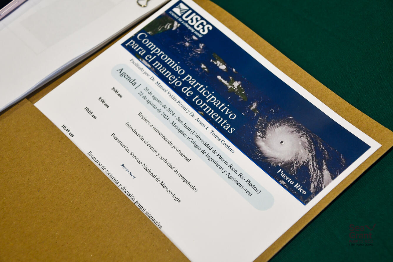 Beige folder opened up with various documents inside. Part of the agenda document is clearly displayed inside the folder.