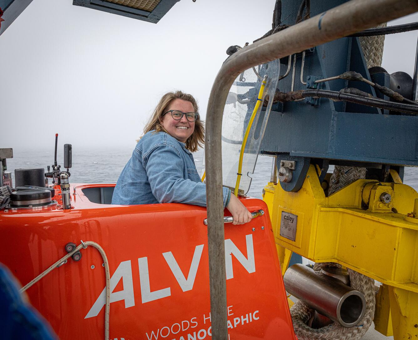 A person smiles while in the entrance to the submersible Alvin