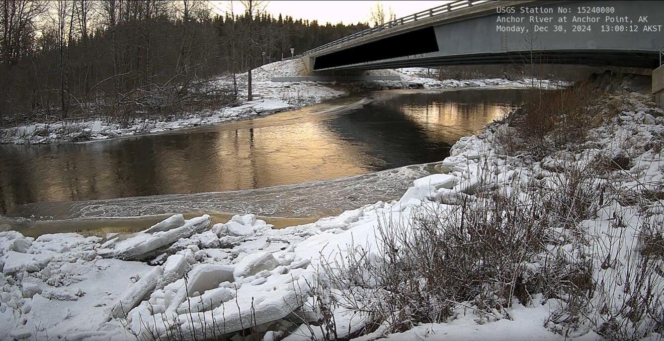 View of Anchor River in Alaska from the riverbank with the road bridge in the background.