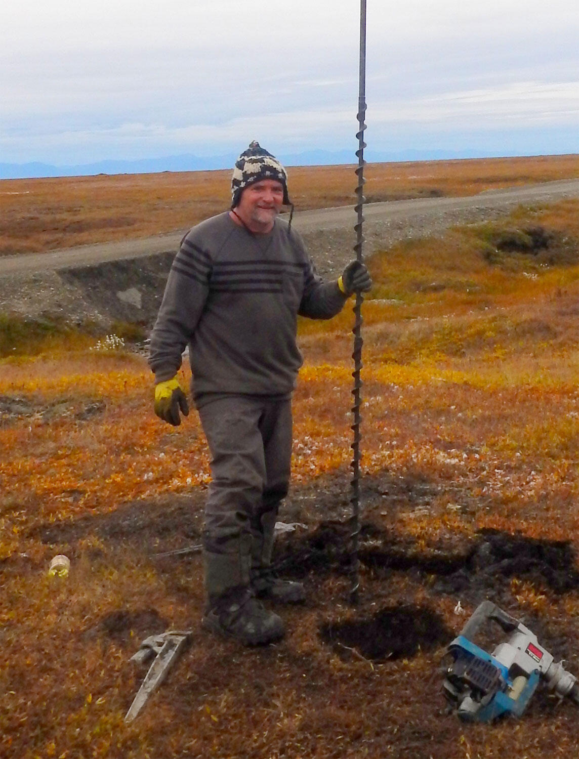 This picture shows USGS scientist Peter Swarzenski conducting fieldwork in a grassy plain on Alaska’s Barter Island.