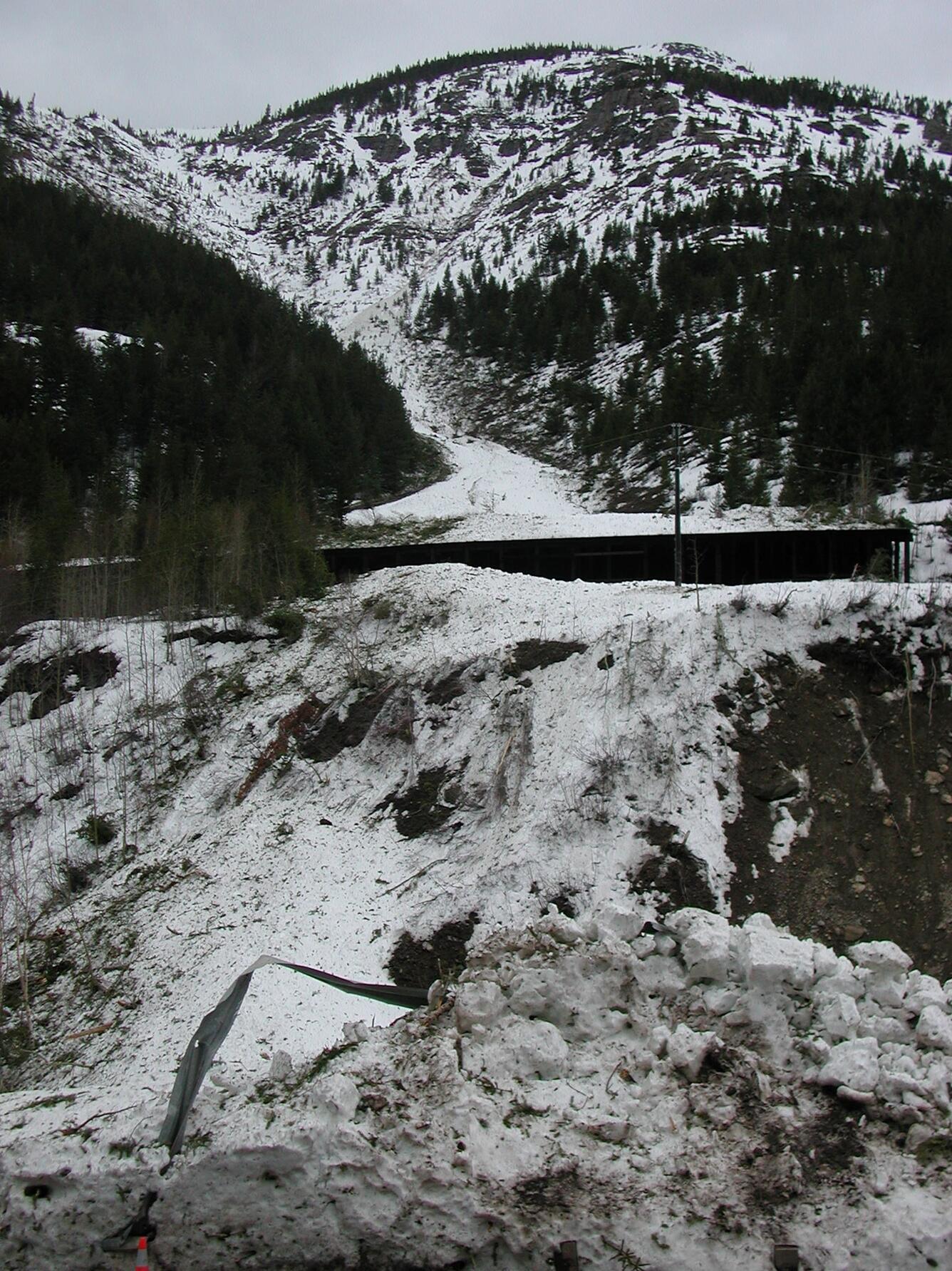 Avalanche debris at end of avalanche path near railway shed