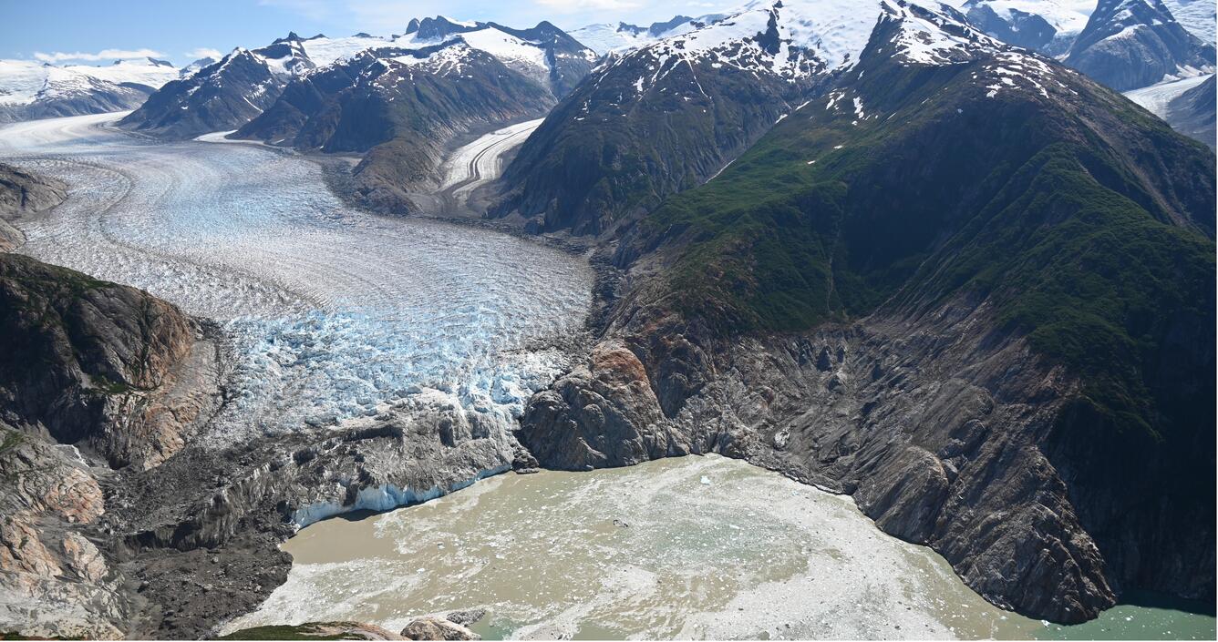 Photo looking towards a glacier on the left and a tsunami runup zone on the mountain on the right 