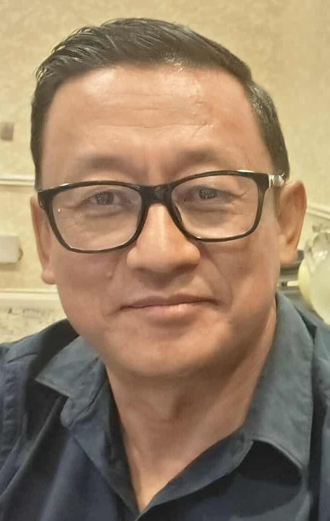 A man with dark hair and glasses