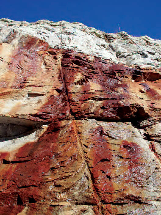 Bedrock outcrop with precipitated iron oxides stained by groundwater