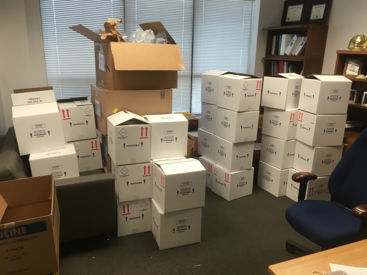 Large office room full of cardboard sample boxes.