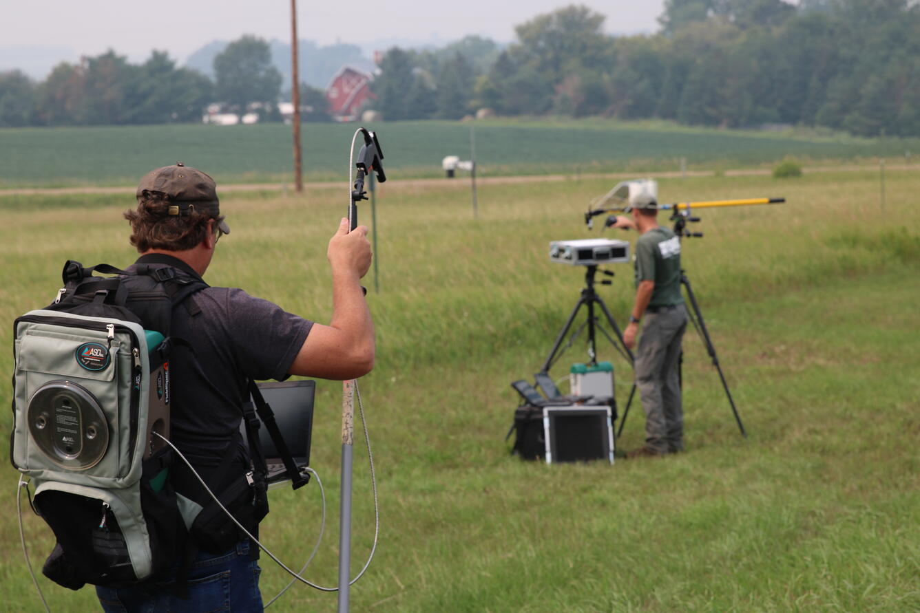 Engineers are photographed in the field monitoring calibration measurements supporting Landsat 