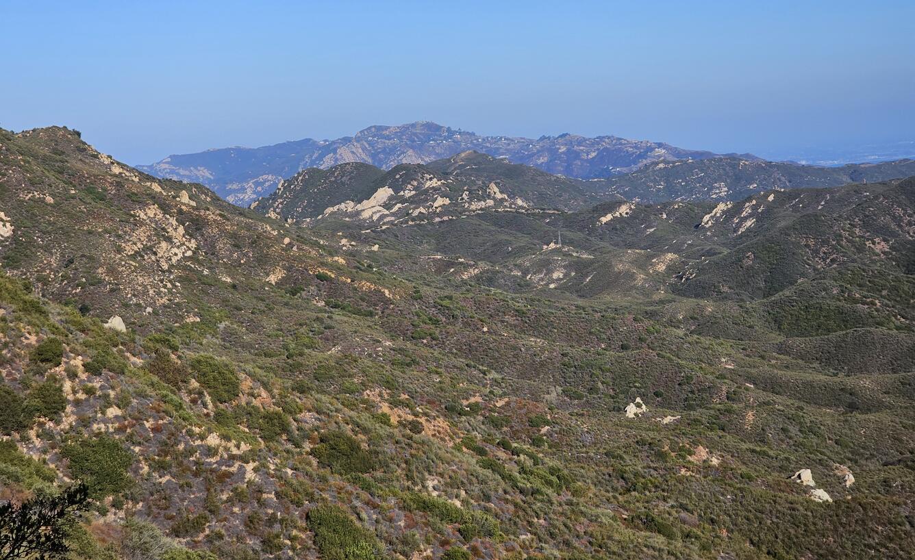 vegetation covered mountains in the image foreground and background