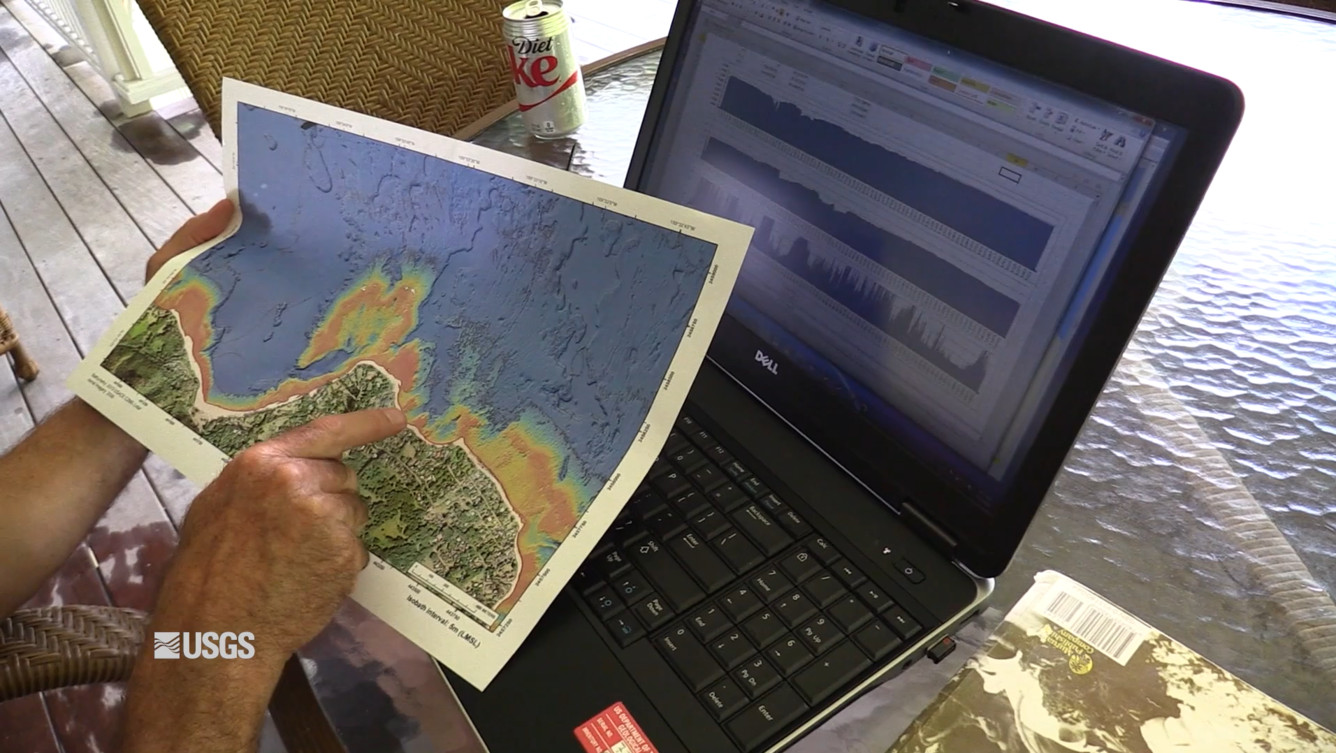Image of researcher at a laptop viewing a coastal change assessment map