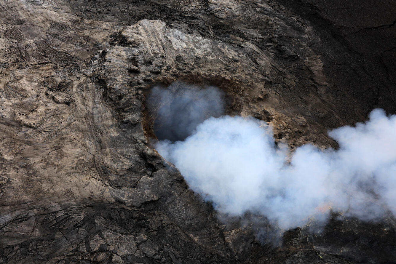 Volcanic vent emitting a thick white volcanic gas plume