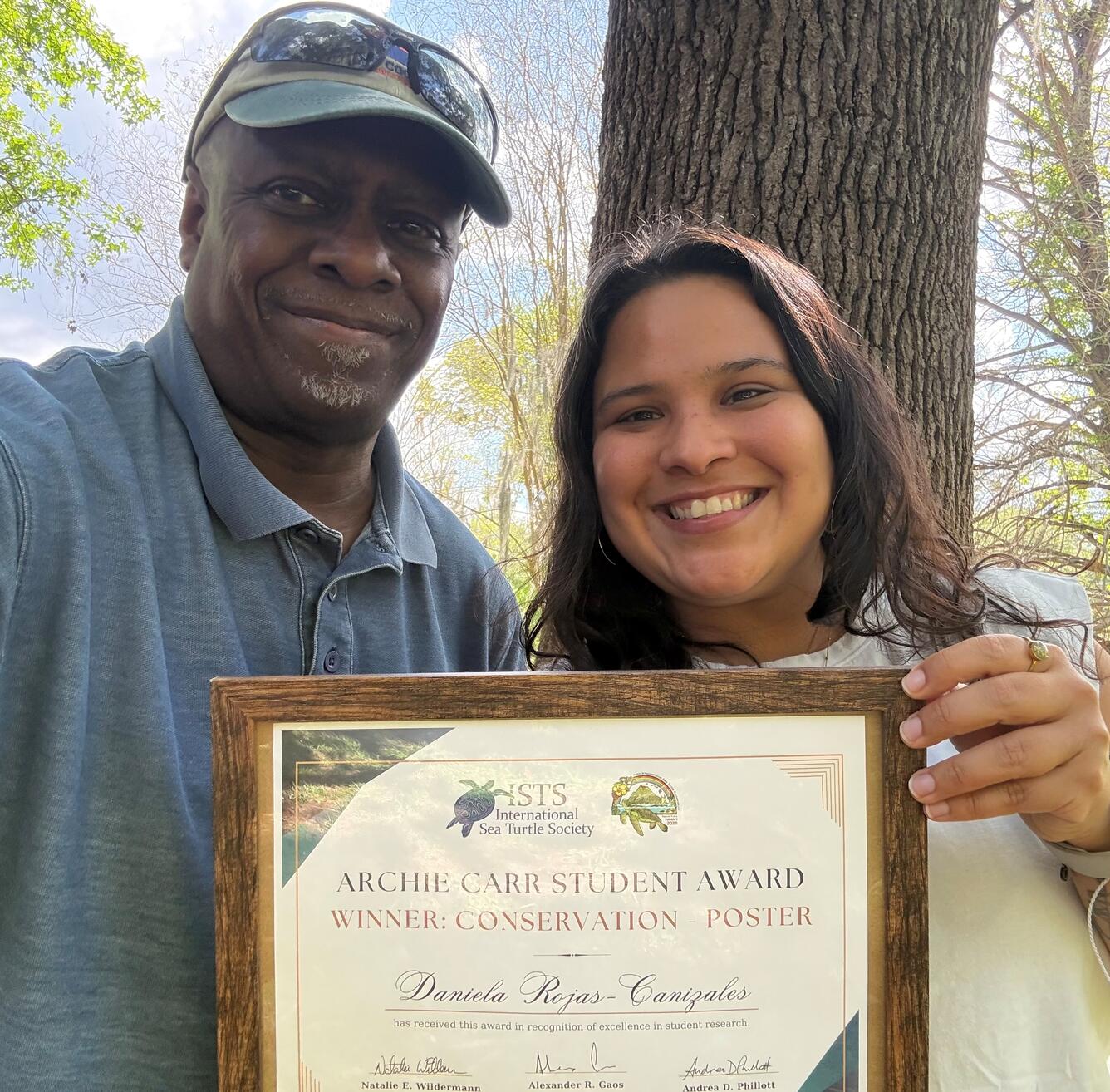 Two people holding an award