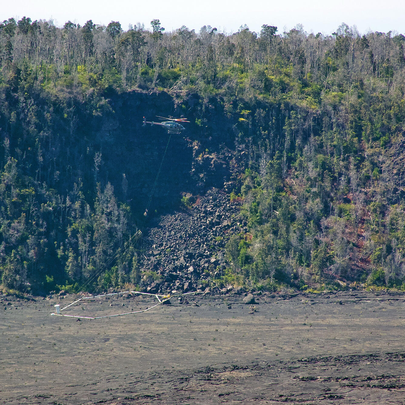 Color photograph of helicopter survey over volcano