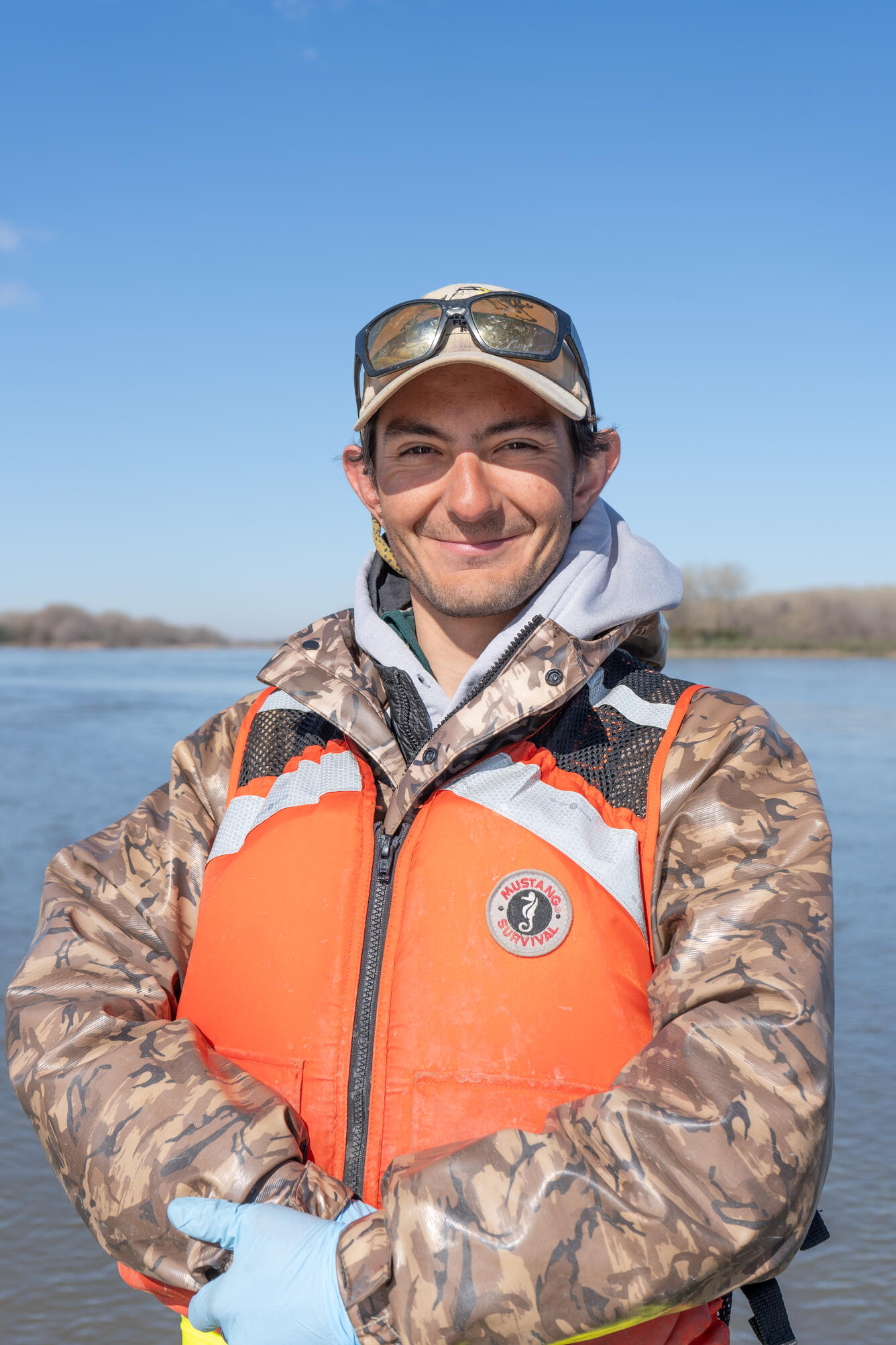profile picture of man smiling with orange life jacket vest and hat