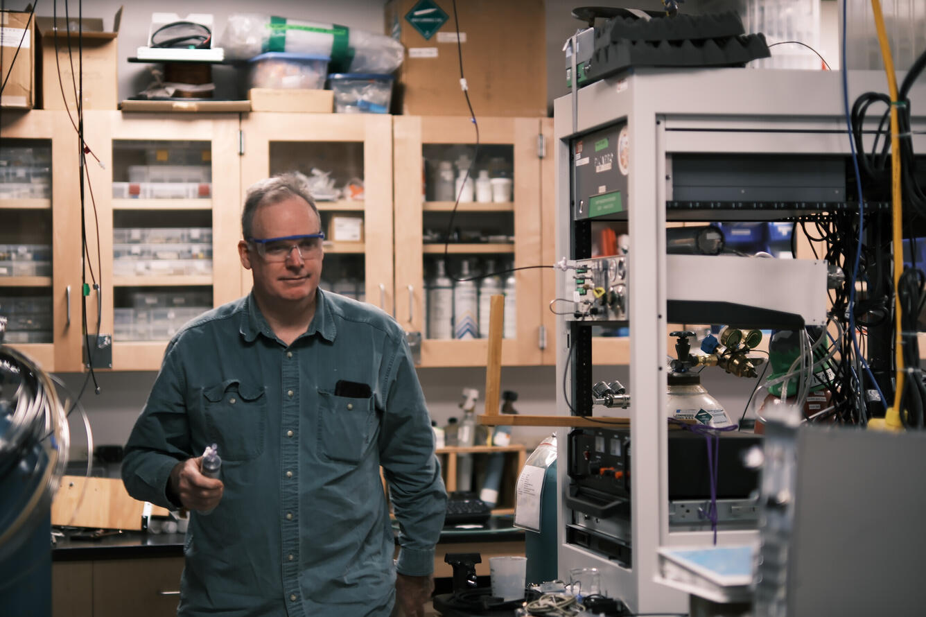 Person holding object in hand walking through a laboratory