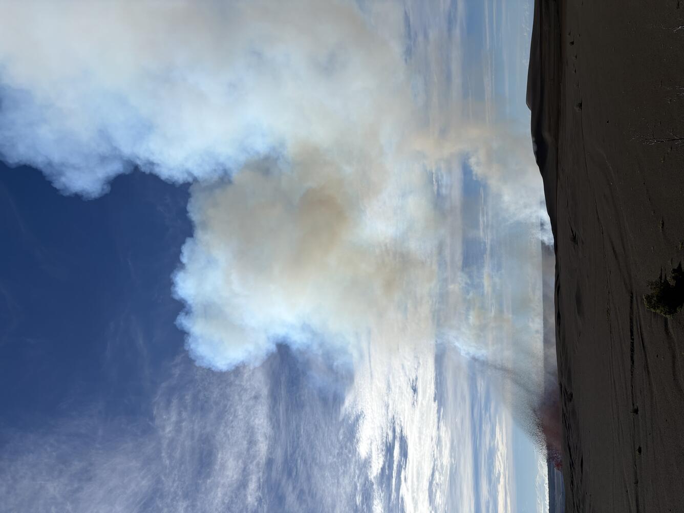 color photo of lava fountain just barely peeking over the crater rim. 